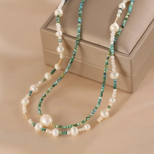 Macro shot of double-layer necklace with natural white pearls and green turquoise beads