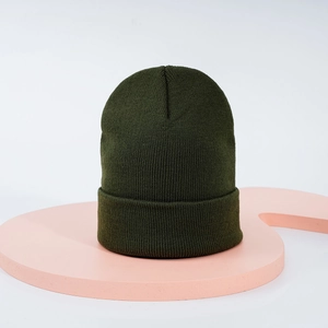 Gros plan détaillé du bonnet vert foncé avec texture en maille fine et revers classique