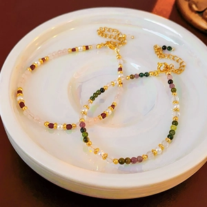 Detail of 18K gold plated beaded bracelets with colorful crystals and pearls on a tray