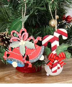 Detail of wooden Christmas bell and candy cane ornaments with festive holly leaves