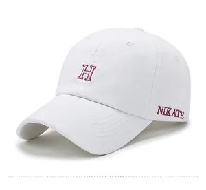 Détail des lettres brodées H et NIKATE sur une casquette de baseball en coton blanc