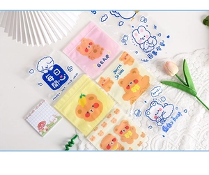 Close-up of cute cartoon snack bags featuring bear and bunny illustrations on a white table