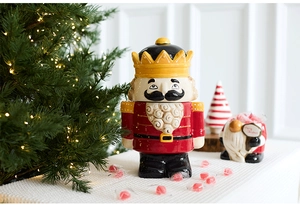 Detail of a ceramic Nutcracker King candy jar with glossy glaze and festive gold accents