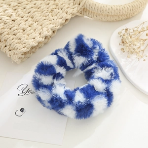 Detailed view of a soft plush blue and white checkered hair scrunchie for winter