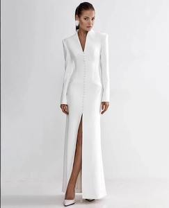 Detail of elegant white V-neck maxi dress with padded shoulders and slit skirt