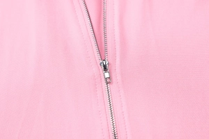 Detailed macro view of high-quality silver metal zipper on pink knitted zip-up hoodie