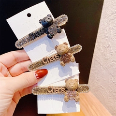Detailed view of three bear-shaped hair clips with rhinestones in black, brown, and beige