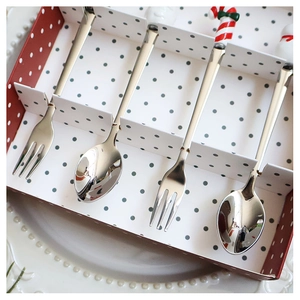 Vue détaillée de cuillères à café et fourchettes de Noël dans leur boîte cadeau