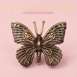 Macro detail of solid brass butterfly ornament with antique bronze relief and fine texture