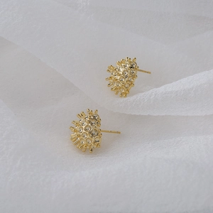 Elegant 18K gold plated heart stud earrings with unique textured finish on soft white fabric