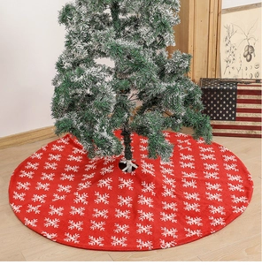 Detail of red Christmas tree skirt featuring white snowflake patterns on plush fabric