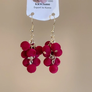 Detail of vintage red velvet grape cluster earrings with gold hooks on a display card