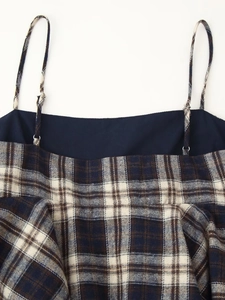 Detail of plaid camisole showing the fabric texture and adjustable shoulder strap buckle