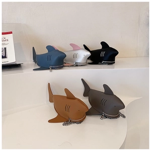 Five shark-shaped leather purses in assorted colors with metal chains and zippers