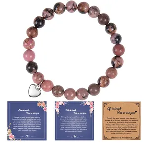 Macro shot of 8mm pink zebra stone bracelet with heart charm and motivational gift cards