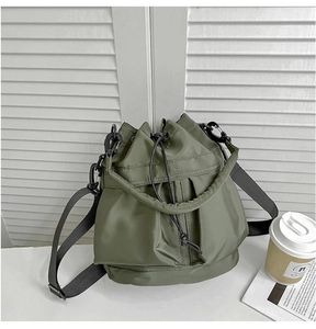 Army green nylon bucket bag featuring a drawstring closure and black adjustable strap