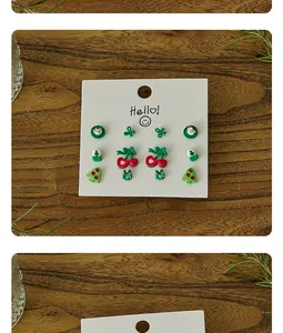 Detailed view of Christmas stud earrings set with pine tree and bear on display card