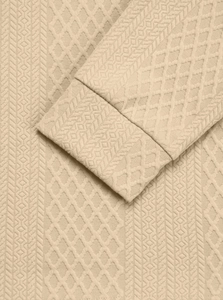 Macro detail of men's beige polo shirt showing textured jacquard knit and ribbed cuffs
