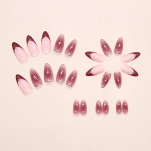 Detail of long almond press-on nails with burgundy French tips and silver starbursts