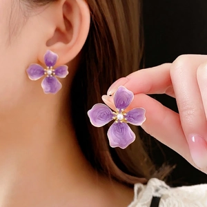 French vintage purple flower earrings with gold edges and pearl center on ear