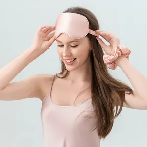 Pink 22 momme silk sleep set with eye mask and hair scrunchie worn by a model