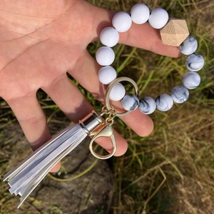 Detail of white silicone beads and hexagonal wood bead keychain with soft white tassel