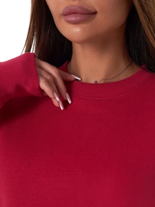 Detail of the ribbed crew neck and soft fabric texture on this red oversized sweatshirt