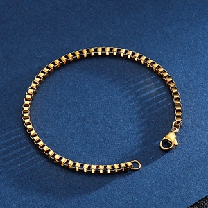 Detailed close-up of golden stainless steel box chain bracelet with lobster clasp