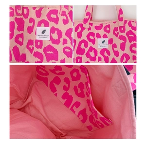 Detailed view of pink leopard tote bag featuring canvas handles and interior pocket