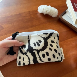 Detail of bohemian linen coin purse with black tassel and simple wish brand label