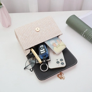 Beige woven crossbody bag with gold buckle and chain, showing interior storage capacity