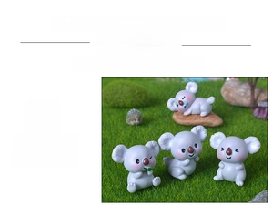 Detailansicht von vier Mini-Koala-Figuren aus Harz auf einem moosgrünen Rasen