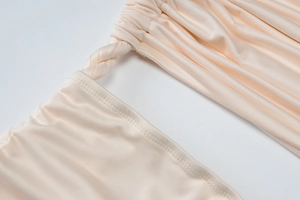 Close-up of the beige knot design and precise double-needle stitching on smooth fabric