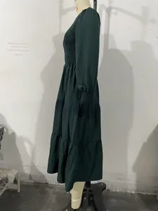 Detail of dark green tiered midi dress with elastic high waist and ruffle cuffs