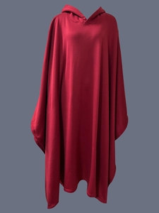 Dettaglio di un mantello punk con cappuccio rosso scuro in pesante jersey con pieghe