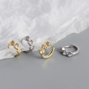 Macro shot of gold and silver plated s925 silver heart shaped hoop earrings
