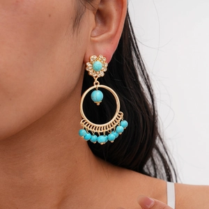Close-up of Bohemian earrings featuring turquoise beads and sparkling rhinestones on model