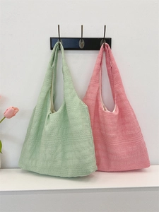 Detail of pink and green pleated tote bags with unique seersucker texture and wide straps