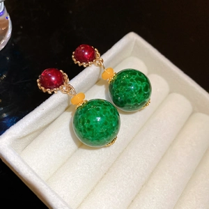 Close-up of vintage resin drop earrings with red, yellow and green marble beads