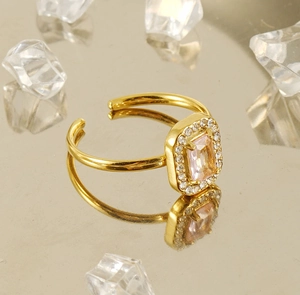 Macro shot of 18K gold ring with a pink rectangular zircon and sparkling crystal accents