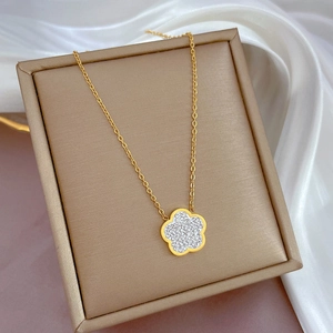Macro view of gold plated flower pendant necklace with shimmering crystal pavé details