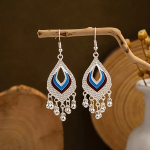 Detailed shot of ethnic silver hollow teardrop earrings with blue and red enamel tassels