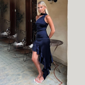 Dettaglio di un elegante abito in raso blu scuro con orlo a balze asimmetrico e taglio asimmetrico