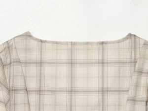 Close-up of the V-neckline and fine plaid fabric texture of the mini dress