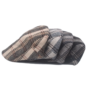 Close-up of three classic tweed newsboy caps in different vintage plaid patterns