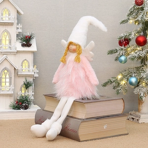 Détail d'une poupée ange de Noël en peluche rose assise sur des livres vintage