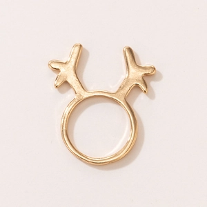 Close-up of golden reindeer antler Christmas ring with smooth metallic finish on beige backdrop