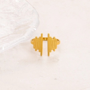 Close-up of golden wavy irregular stainless steel ring on a textured marble background