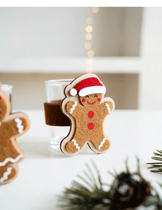 Nahaufnahme der Lebkuchenmann-Hülle aus Filz mit Weihnachtsmütze auf einem Glaswindlicht