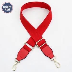 Detail of bright red canvas strap with gold swivel hooks and adjustable buckle